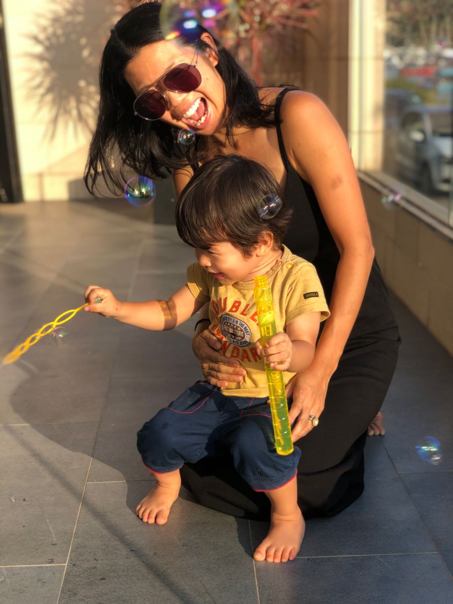 Tammie laughing with her young child in the sunshine