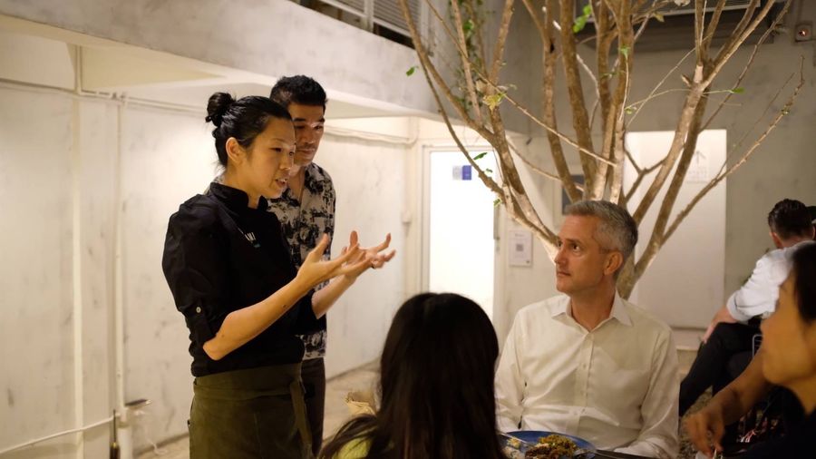 Tammie talking with guests around a table