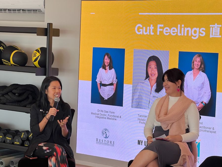 Tammie speaking on a panel at AIA in front of a 'Gut Feelings' banner