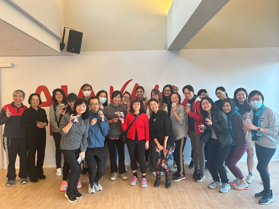 Tammie with a large group of workshop participants at AIA, each holding up a jar