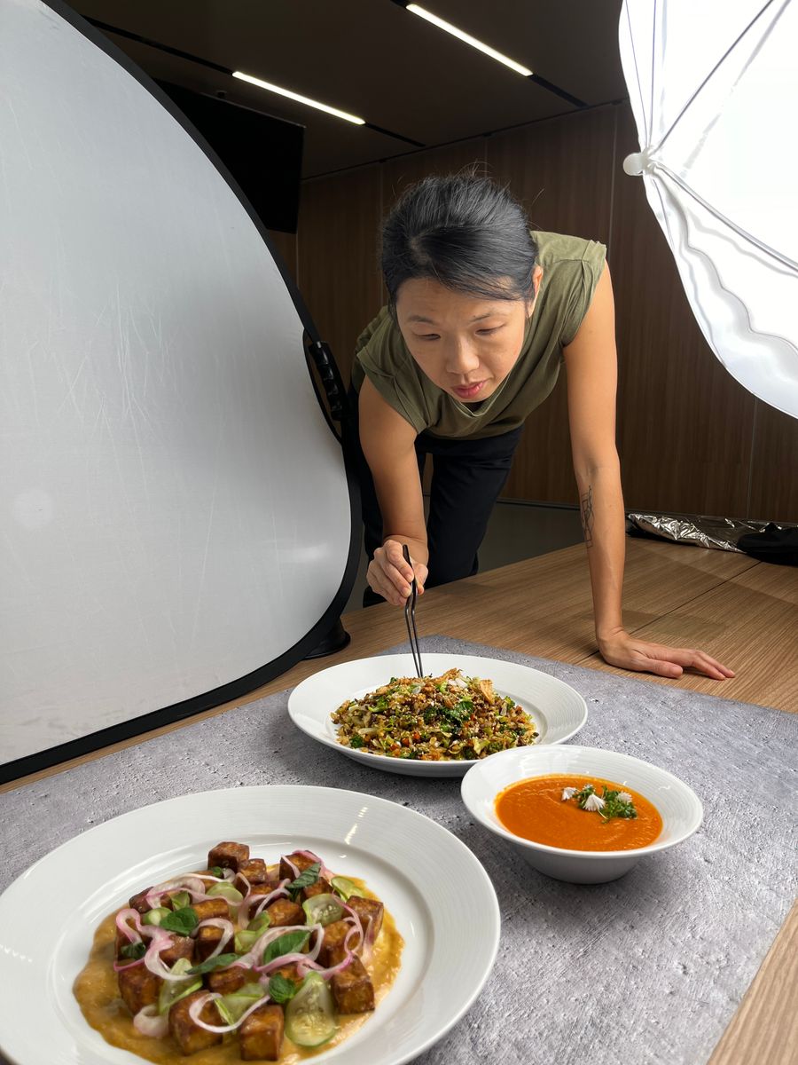 Tammie plating dishes at a photoshoot for The Food School